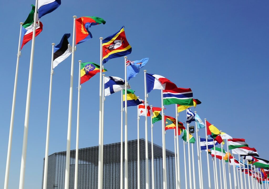 U.S. diplomats huddle at UNGA desks counting yellow vote cards while Russian seat sits empty in Geneva council chamber.