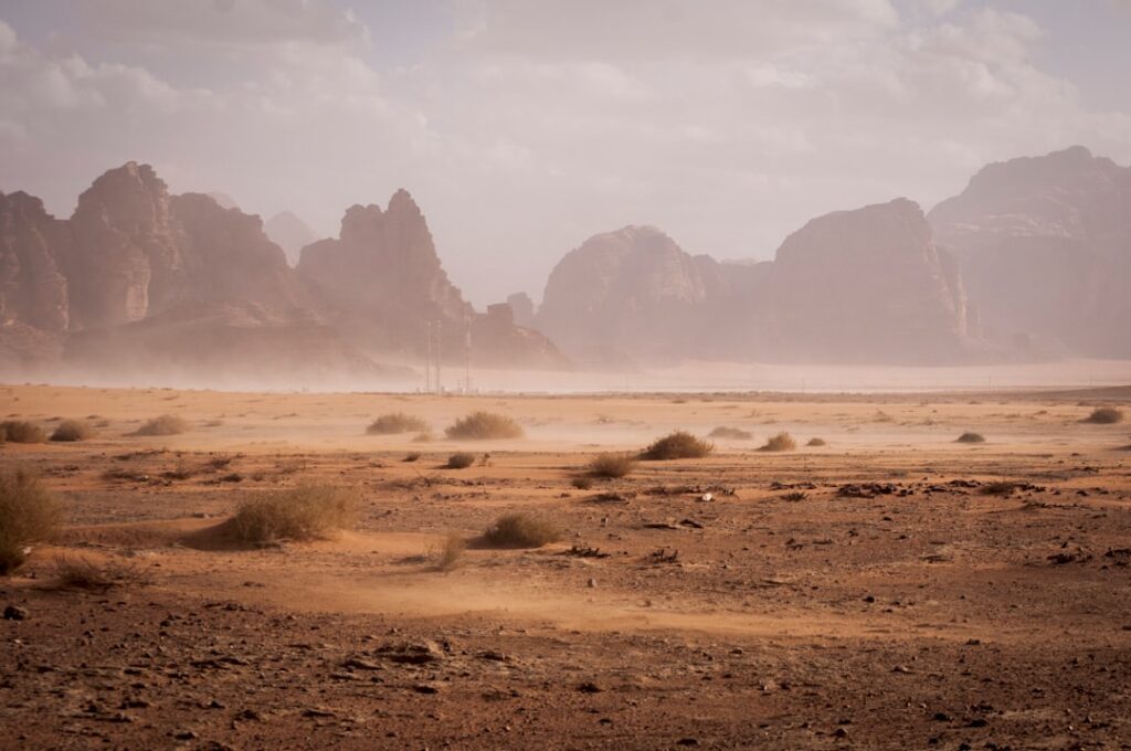A damaged vehicle lies overturned on a desert road near the Kufra oasis, with emergency responders nearby.