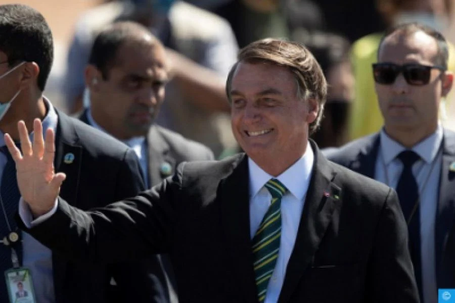 Jair Bolsonaro stands before the Brazilian flag at the end of his presidential term, July 2023.